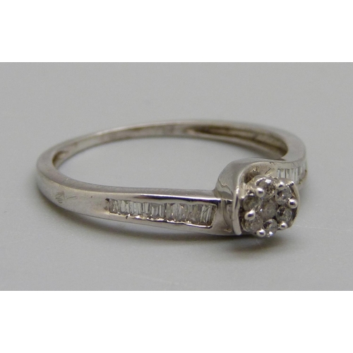 955 - A silver ring set with seven brilliant cut diamonds and eighteen baguette cut diamonds, S