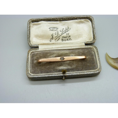 979 - A 9ct gold bar brooch set with a diamond, 2g, and a yellow metal mounted pendant