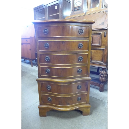 100 - A small yew wood serpentine chest of drawers