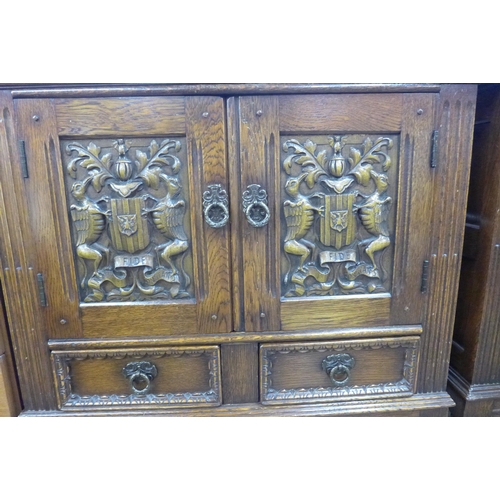 109 - A pair of carved oak armorial credence cupboards