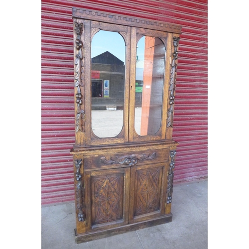 114 - A Victorian Jacobean Revival carved oak freestanding corner cabinet