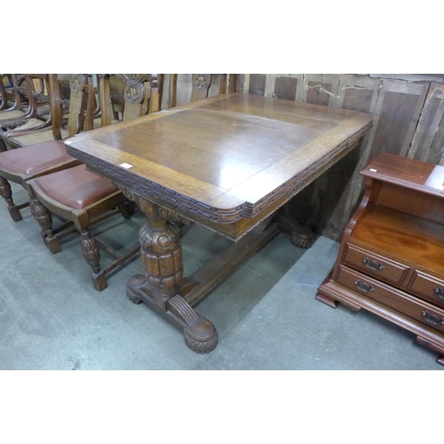 122 - A carved oak draw leaf table and four chairs