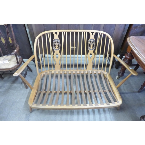 140 - An Ercol beech fleur de flys settee