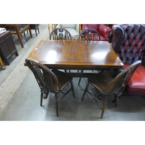 245 - An oak draw leaf refectory table and four beech wheelback chairs