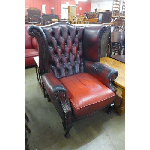 246 - An oxblood red Chesterfield wingback armchair