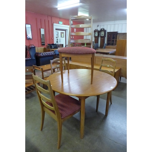 63 - A teak extending dining table and four G-Plan teak dining chairs