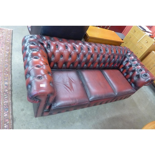 68 - An oxblood red leather Chesterfield settee