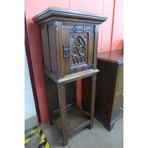 90 - A Elizabethan Revival carved oak cupboard on stand