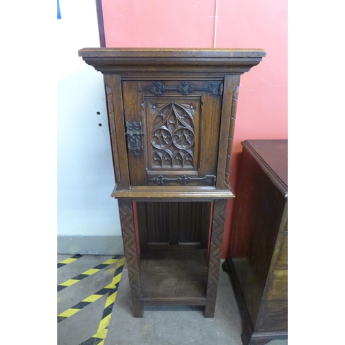 90 - A Elizabethan Revival carved oak cupboard on stand