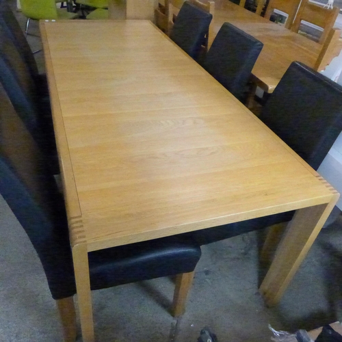 1531 - An Ercol oak Bosco range extending dining table together with  six black leather chairs