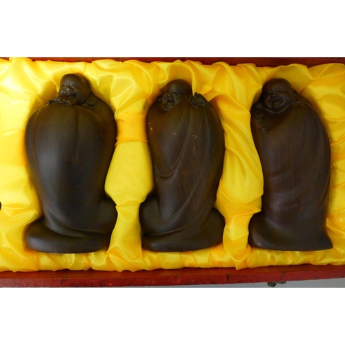 1005 - Five wooden Buddha figures, cased