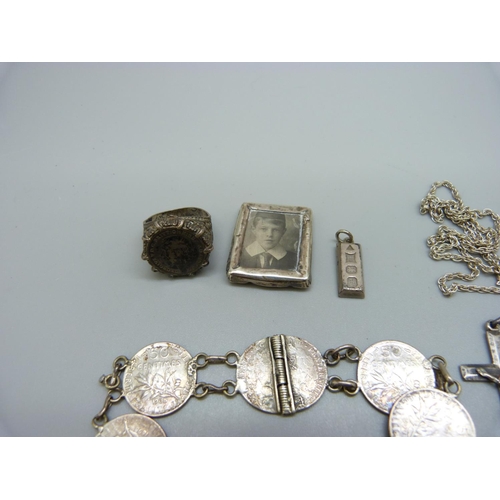 925 - A silver pendant and chain, a small silver ingot pendant, a silver bracelet, a silver ring, a coin b... 