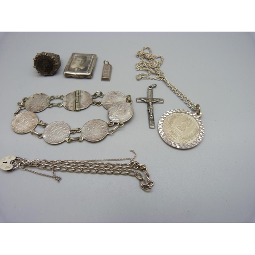 925 - A silver pendant and chain, a small silver ingot pendant, a silver bracelet, a silver ring, a coin b... 