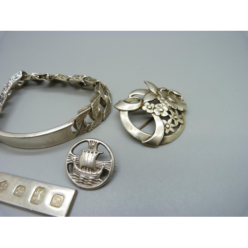 956 - Silver including an ID bracelet, a Scottish brooch, one other brooch and an ingot pendant, 116g