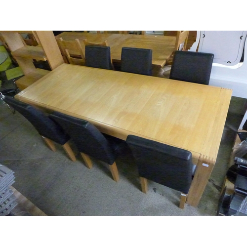 1529 - An Ercol oak Bosco range extending dining table together with six black leather chairs