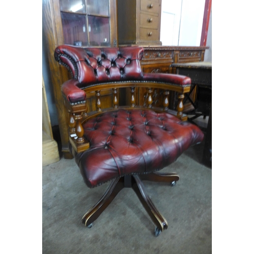 121 - A mahogany and oxblood leather revolving Captain's desk chair