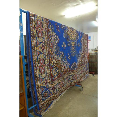 186 - A large blue ground rug, 375 x 280cms