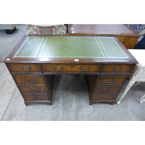 194 - A mahogany and green leather topped pedestal desk