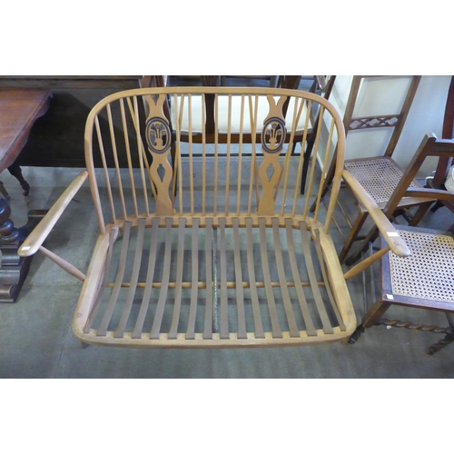 224 - An Ercol beech fleur de flys settee