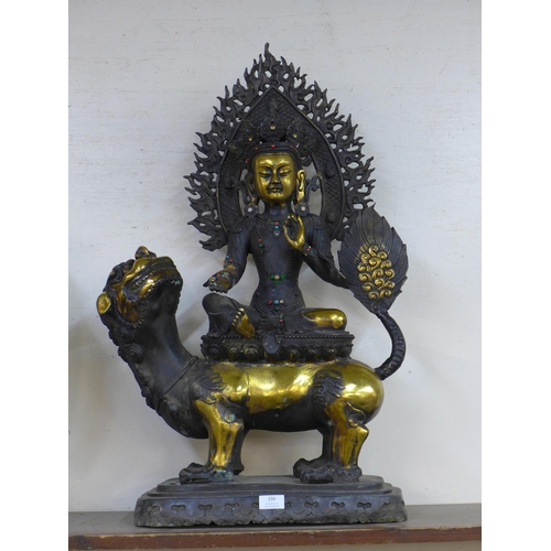 336 - A large oriental bronze figure of a seated deity on dog of foe