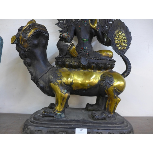 336 - A large oriental bronze figure of a seated deity on dog of foe