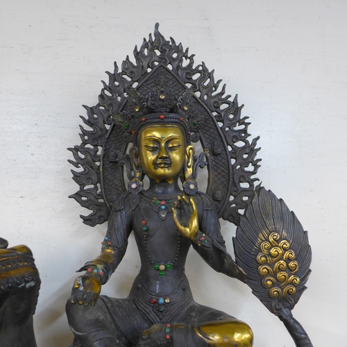 336 - A large oriental bronze figure of a seated deity on dog of foe