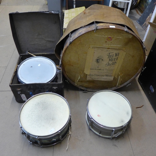 383 - A vintage bass drum, two snare drums and a small tom tom drum, drum sticks and brushes