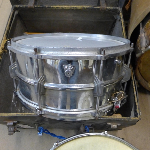 383 - A vintage bass drum, two snare drums and a small tom tom drum, drum sticks and brushes