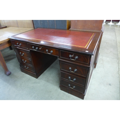 128 - A mahogany and red leather topped pedestal desk