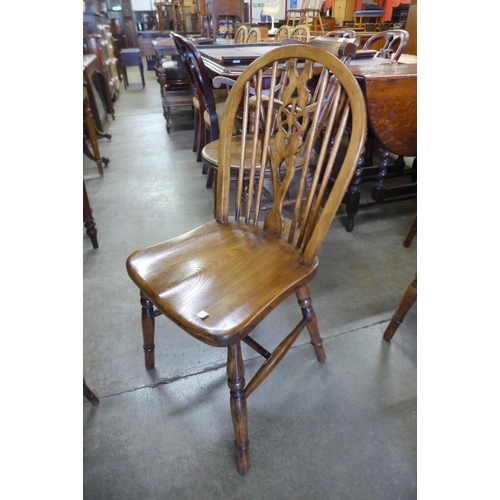 144 - A set of four elm and beech wheelback kitchen chairs