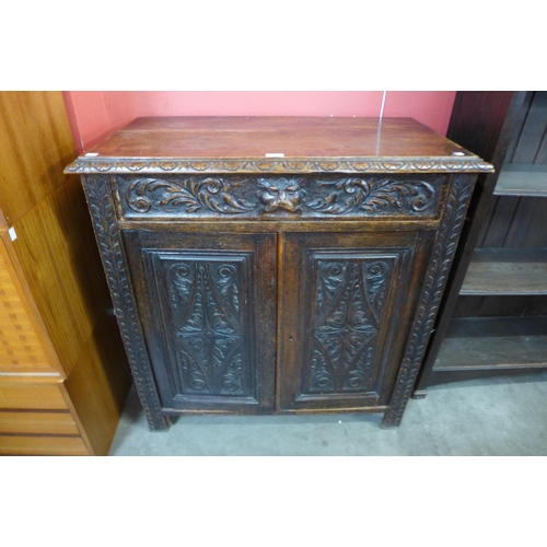 15 - A Victorian Jacobean Revival carved oak green man cupboard