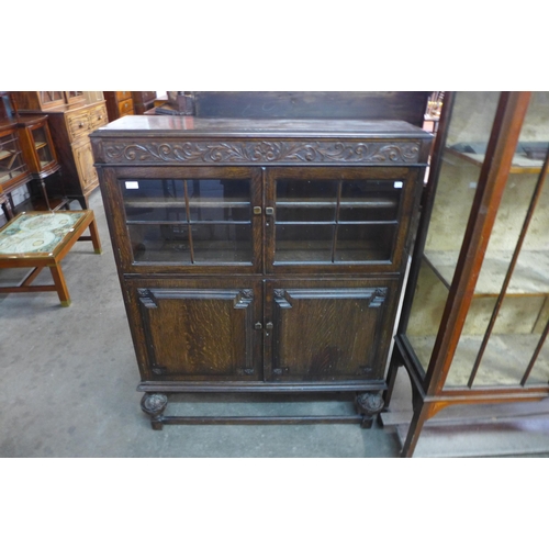 164 - An early 20th Century carved oak four door bookcase