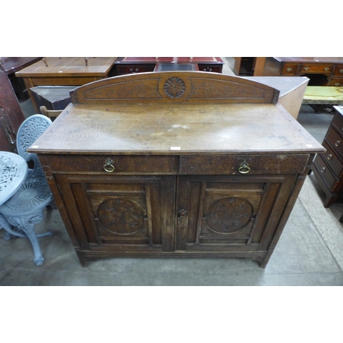 170 - An Arts and Crafts carved oak sideboard