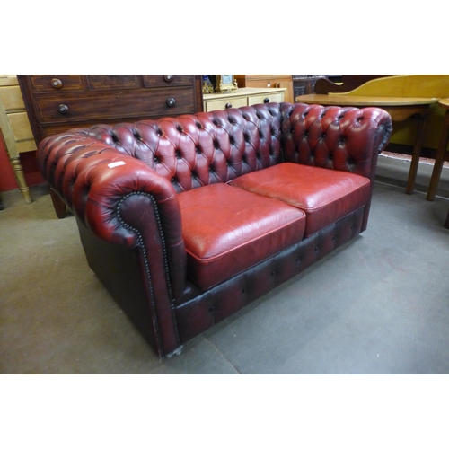 25 - An oxblood leather Chesterfield Settee