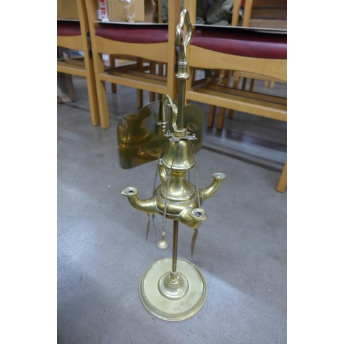 1105 - A brass four arm oil lamp with shield, a pair of brass candlesticks on wood base with removable top,... 