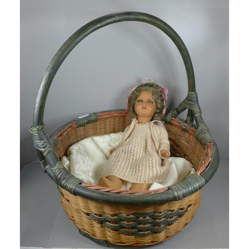 852 - A mid 20th Century composition doll and a wicker basket