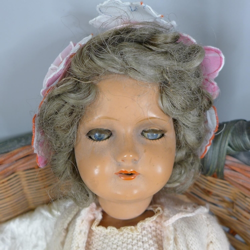 852 - A mid 20th Century composition doll and a wicker basket