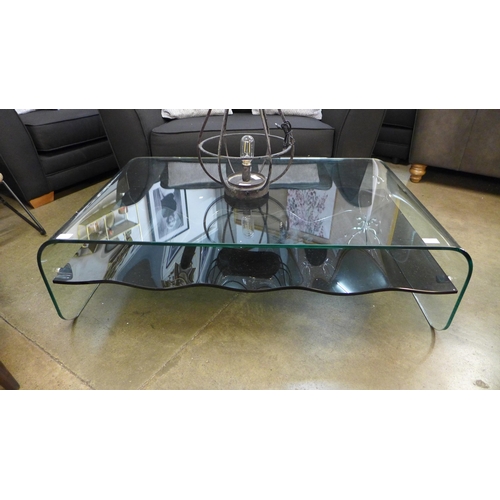 1335 - A clear glass coffee table with black glass wave effect shelf * this lot is subject to VAT