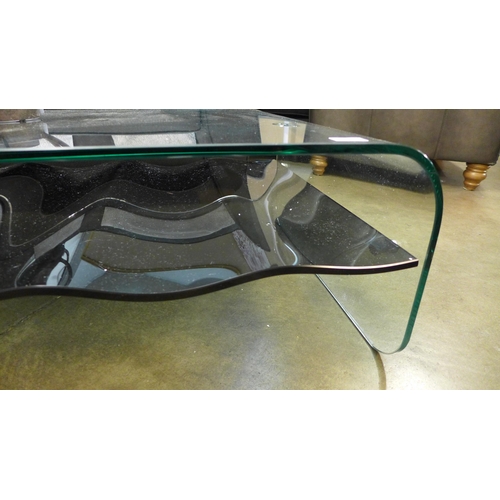 1335 - A clear glass coffee table with black glass wave effect shelf * this lot is subject to VAT