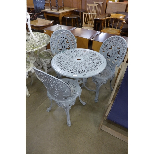 250 - A painted cast aluminium garden table and three chairs