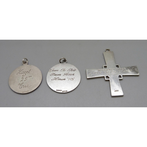 1033 - Two large St. Christopher pendants and a silver cross pendant, all with inscriptions, 49g