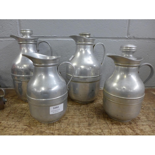 1092 - Four early Thermos flasks, one lacking stopper and a pair of early roller skates