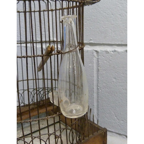 690 - A French wire work bird cage with original glass bottle, circa 1850-1880, 53cm tall, damage to lower... 