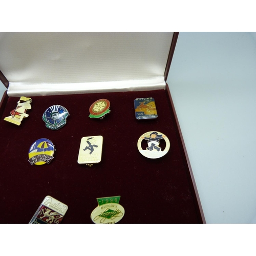 831 - Nine Butlins pin badges, with case