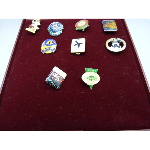 831 - Nine Butlins pin badges, with case