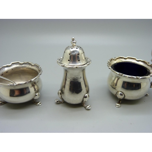 856 - A three piece silver cruet set, Birmingham 1926, and a silver salt spoon, 105g