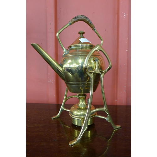 10 - An Arts and Crafts brass spirit kettle on stand