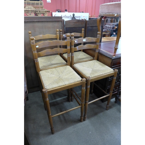 139 - A set of four beech ladderback rush seated bar stools