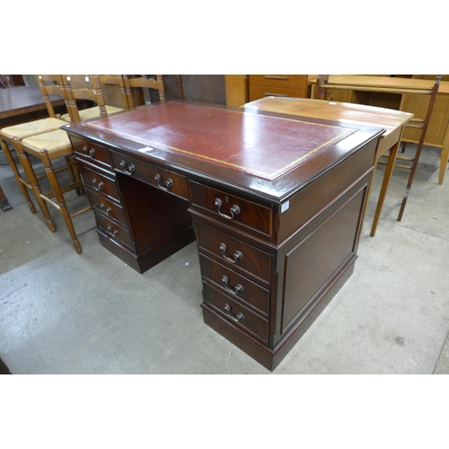 142 - A mahogany and red leather topped pedestal desk