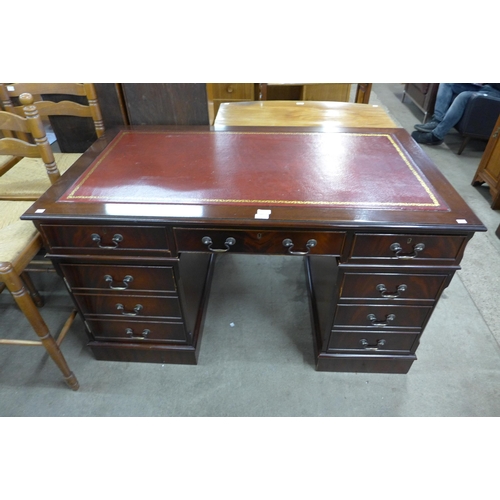 142 - A mahogany and red leather topped pedestal desk